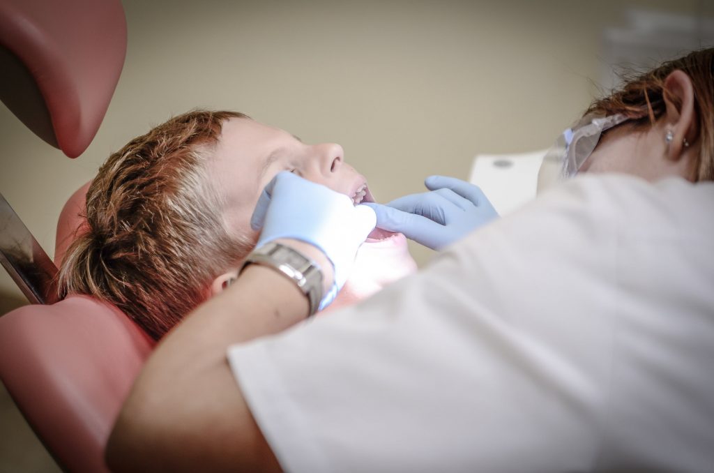 Dentiste qui examine les dents d'un enfant