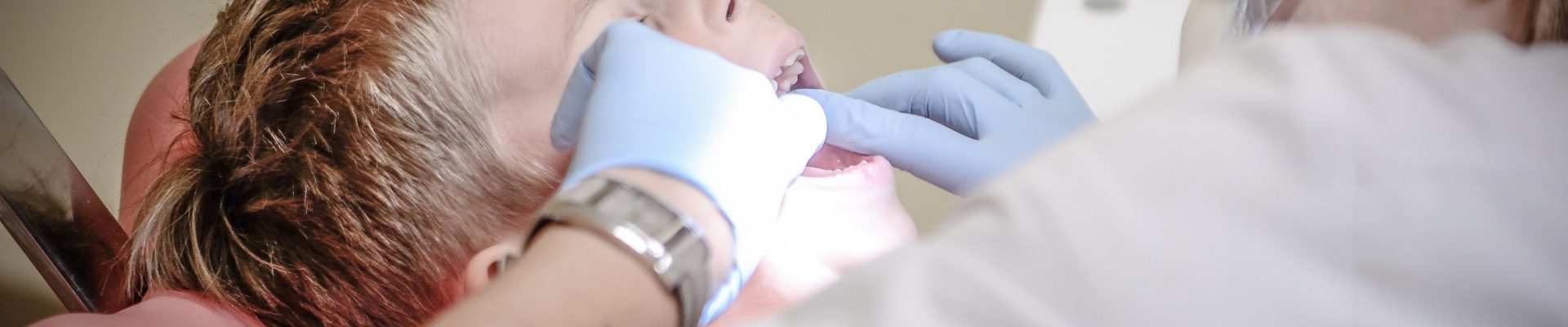 Dentiste qui examine les dents d'un enfant
