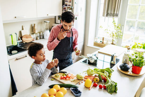 Père qui cuisine une salade de fruits avec son fils