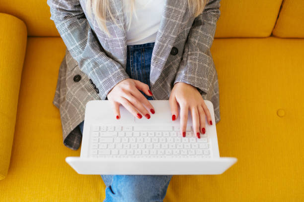 Jeune fille qui tape sur le clavier de son ordinateur portable