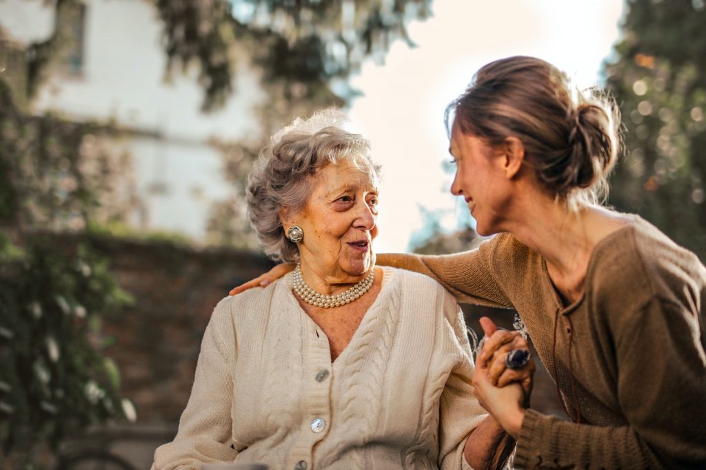 une femme tenant la main à une femme âgée