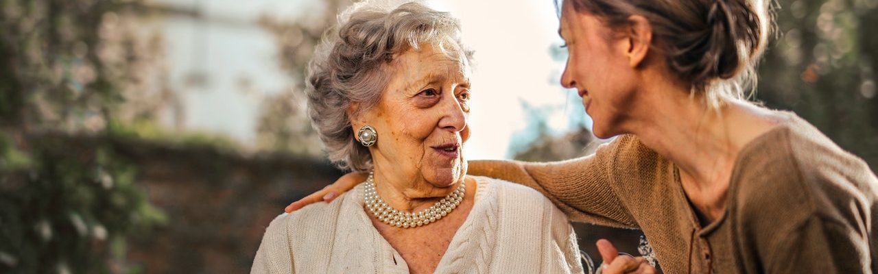 une femme tenant la main à une femme âgée